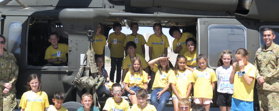 Members of the New Mexico Army National Guard, from left, Capt. Dustin Offret, Chief Warrant Officer 3 Anita Guderjohn, Sgt. Benjamin Vasquez, and students stand in front of an Army UH-60 Black Hawk helicopter during the Air Force Research Laboratory's DOD STARBASE STEM Camp at Kirtland Air Force Base, New Mexico, June 14, 2022.