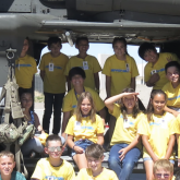 Members of the New Mexico Army National Guard, from left, Capt. Dustin Offret, Chief Warrant Officer 3 Anita Guderjohn, Sgt. Benjamin Vasquez, and students stand in front of an Army UH-60 Black Hawk helicopter during the Air Force Research Laboratory's DOD STARBASE STEM Camp at Kirtland Air Force Base, New Mexico, June 14, 2022.